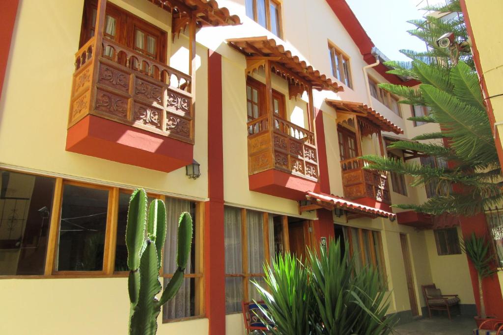 a building with windows and a cactus in front of it at Hospedaje Kamila in Cusco