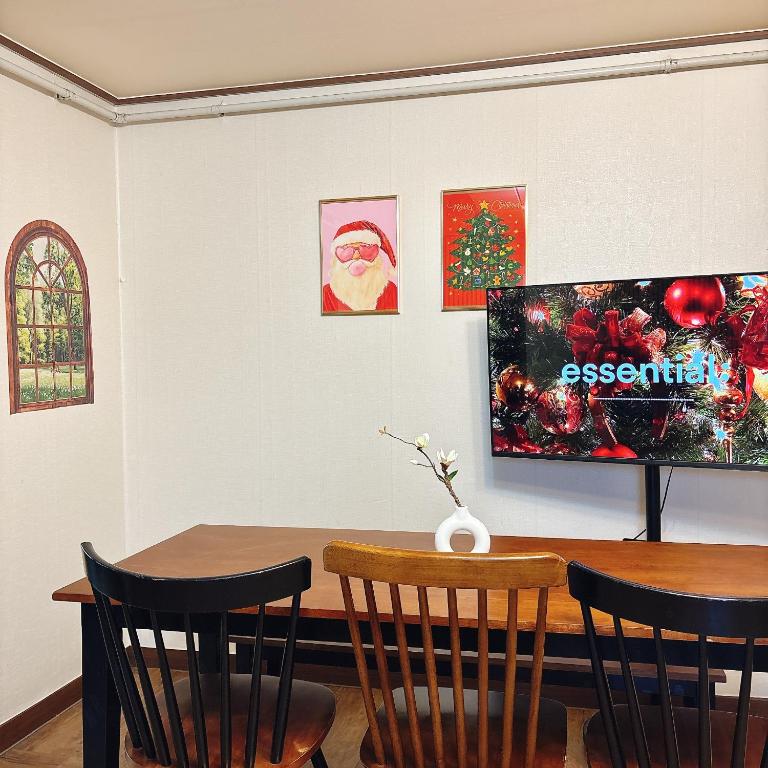 a dining room with a table and a tv at Daegu Stay Hoya in Daegu