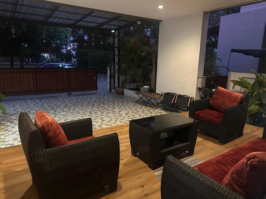 Una sala de estar con dos sillas y una mesa. en บ้านเดี่ยวหางดง ย่านมหาวิทยาลัยนอร์ทเชียงใหม่, en Ban Phae Buak Ha