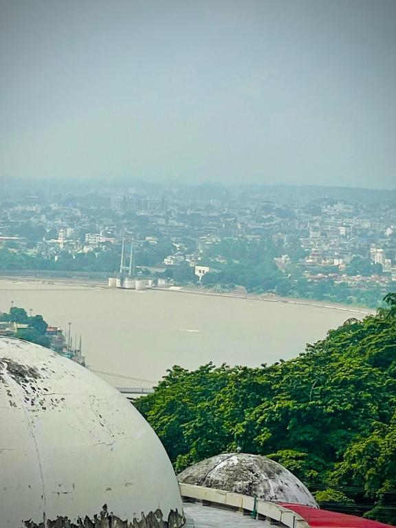 a view of a body of water with a city at Hotel Mount View Inn with terrace Ganga view- near Laxman jhula, Tapovan Rishikesh in Rishīkesh