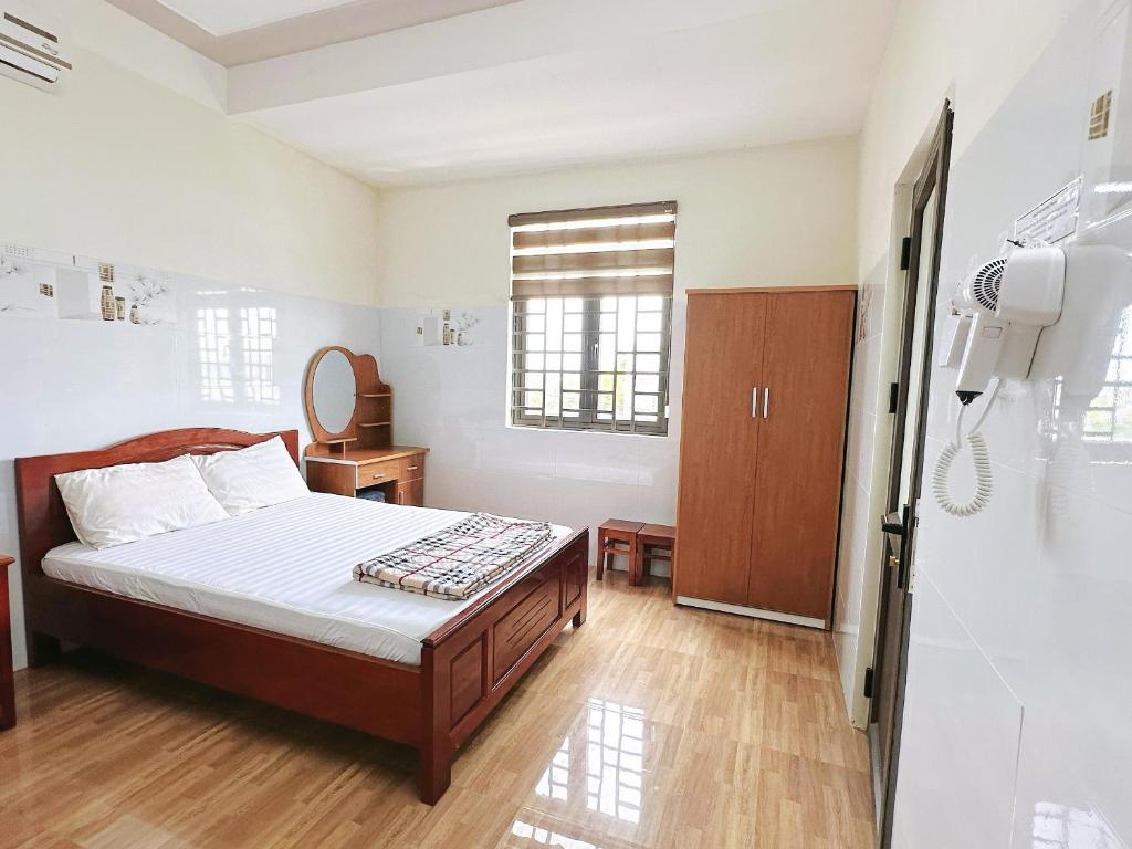 a bedroom with a bed and a bathroom with a shower at Nhà Nghỉ Thành Duy in Quang Ngai