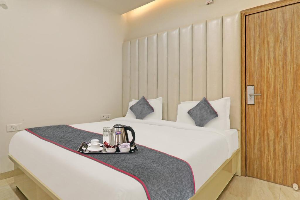 a hotel room with a bed with a tea set on it at Super Townhouse Hotel Impact in Lucknow