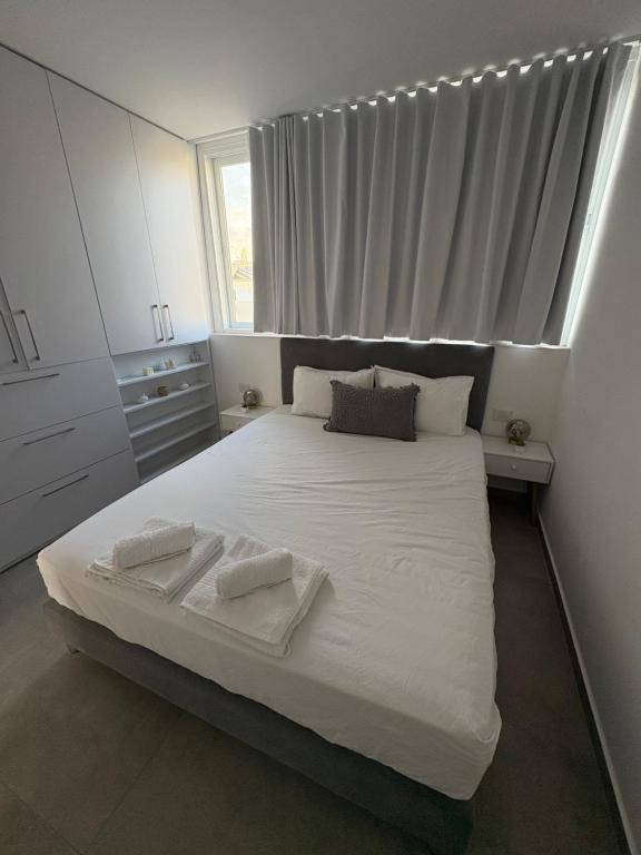 a bedroom with a large bed with two towels on it at Boutique apartment in Rishon LeẔiyyon