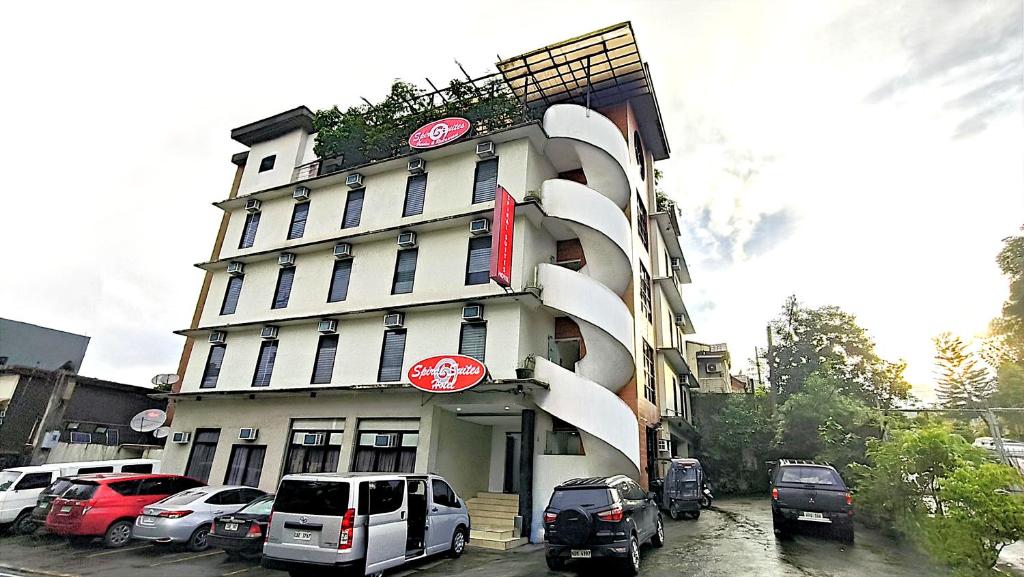 a building with cars parked in front of it at Spiral Suites Hotel in Manila