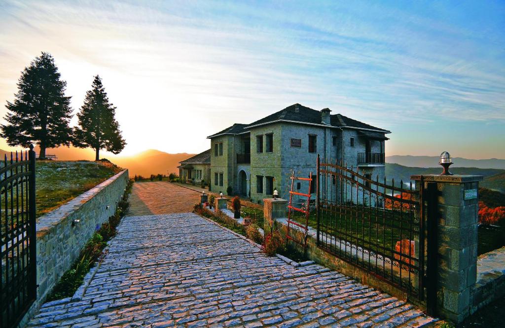 an old house on a hill with a fence at Papigiotis Hotel in Tsepelovo