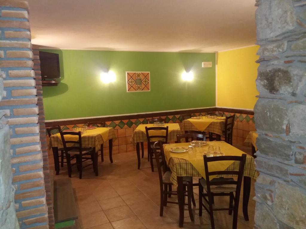 a dining room with tables and chairs and a green wall at Hotel Sant'Anna in Floresta