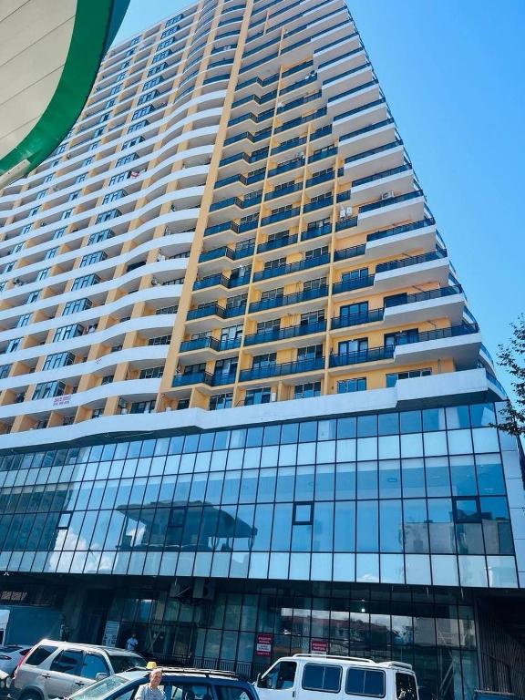 a tall building with cars parked in front of it at PushkinApart in Batumi