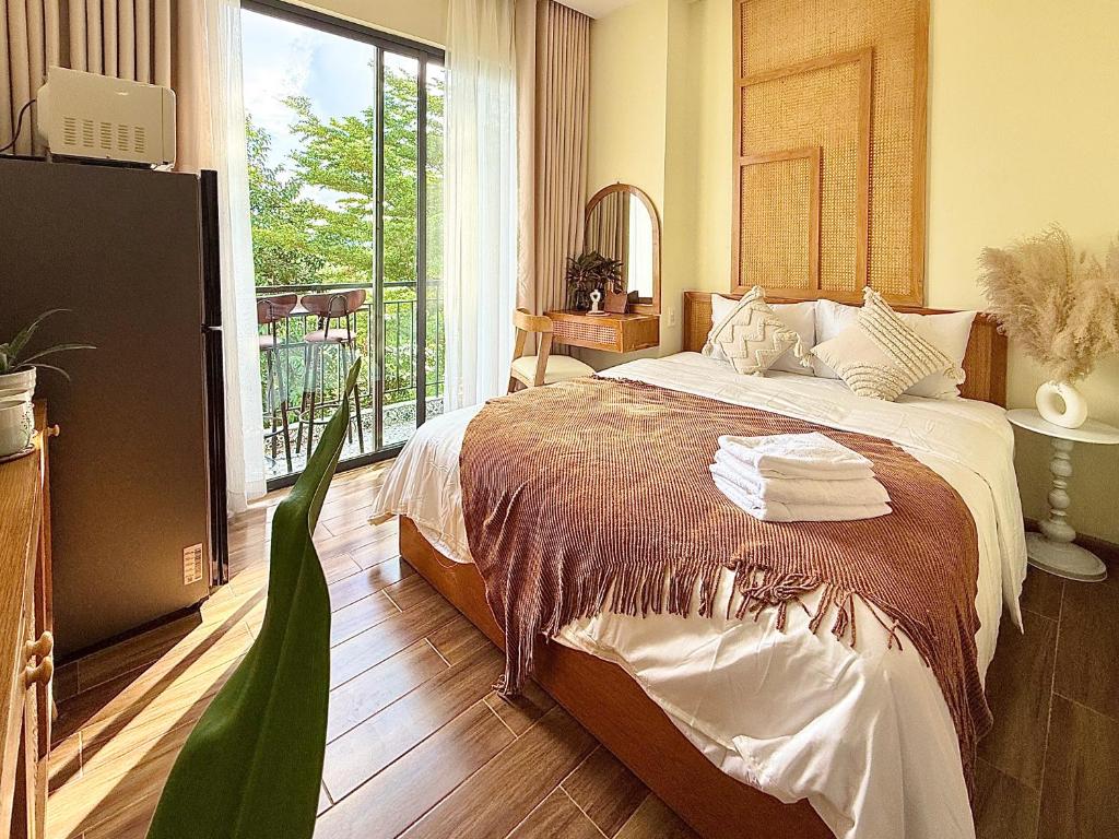 a bedroom with a bed and a large window at The Little Danang in Da Nang