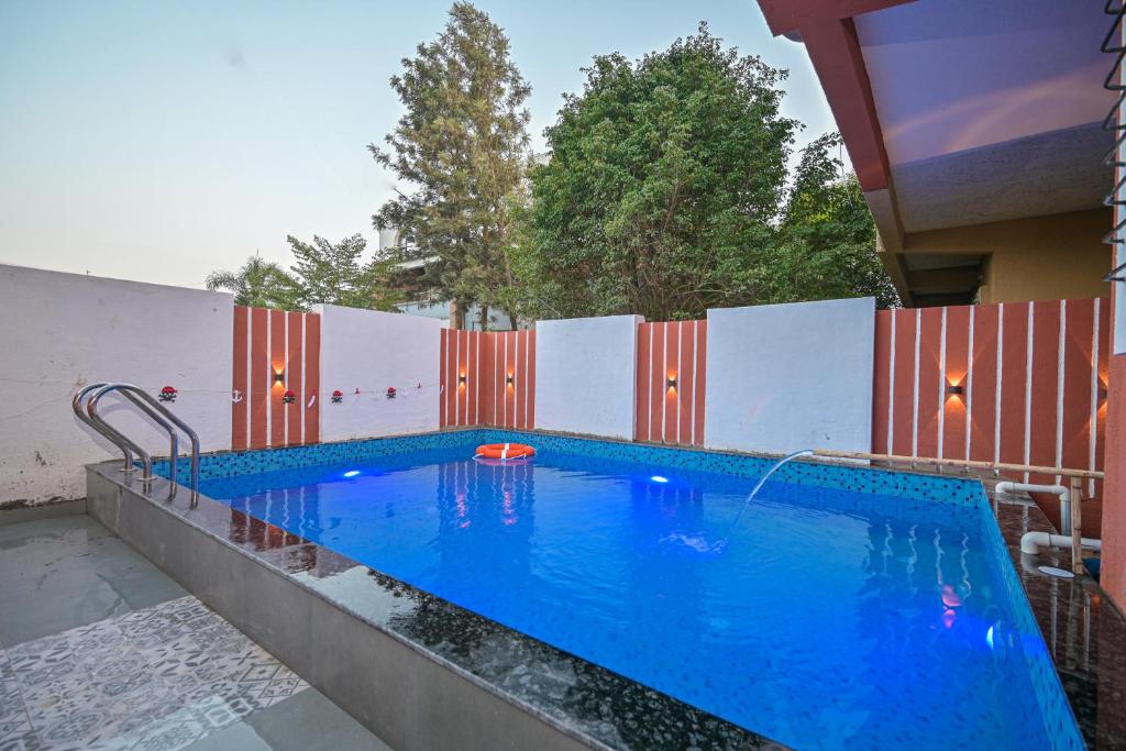 a swimming pool in front of a fence at ll EMPYREAN STAY ll 2BHK ll LUCIFER VILLA ll AC ll PRIVATE POOL ll in Lonavala