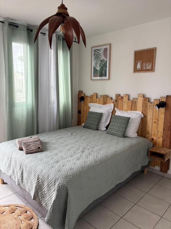 a bedroom with a large bed with green curtains at Evasion du Lagon in Saint-Pierre