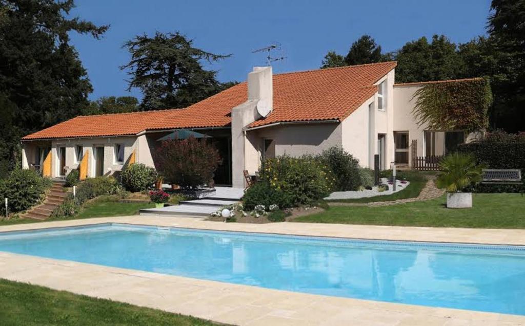 a house with a swimming pool in front of a house at Logis du Parc in Saint-Fulgent