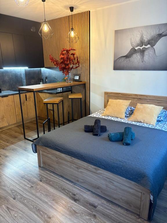 ein Schlafzimmer mit einem Bett mit zwei blauen Schuhen darauf in der Unterkunft Apartament Kozigród in Tczew