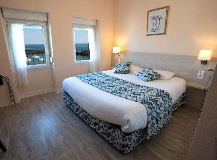 Un dormitorio con una cama grande con dos almohadas encima. en Hotel De La Mer, en Quiberon