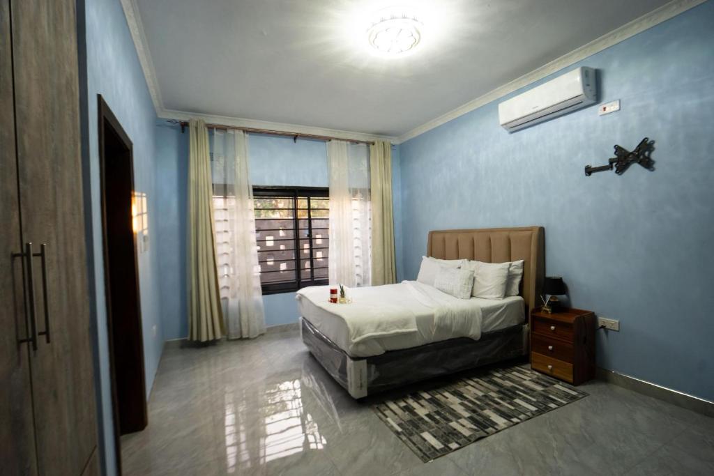 una camera da letto blu con un letto e una finestra di Modern and cozy apartment a Lusaka