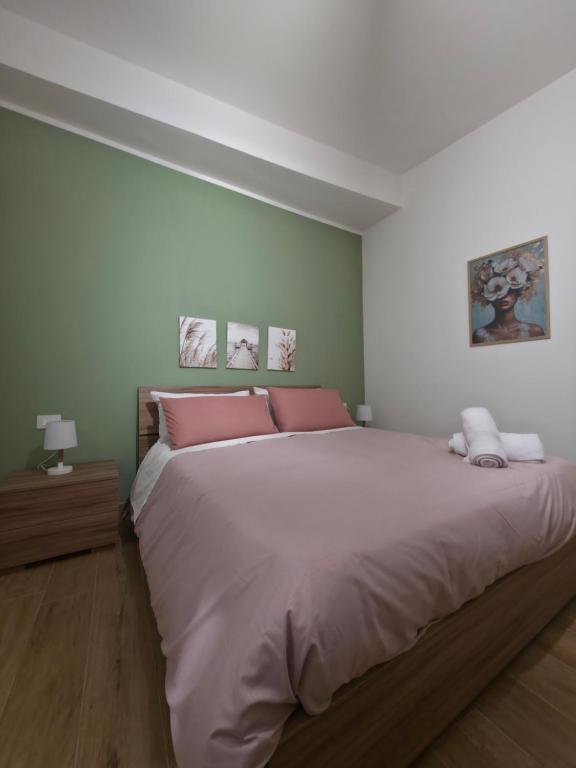 ポッツオーリにあるMaison Luisaのピンクの枕が付いた大きなベッドのある寝室