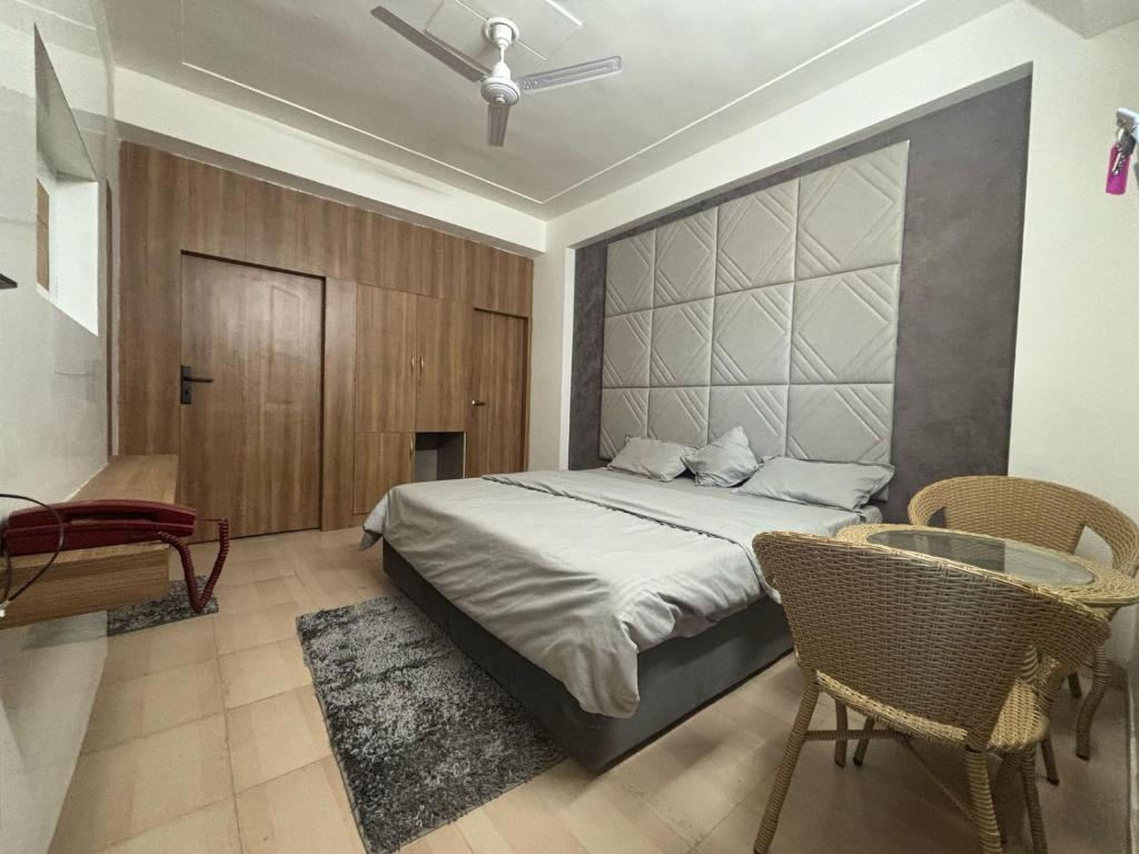 a bedroom with a bed and a table and chairs at Hotlel Sanjivani Salasar in Juliāsar