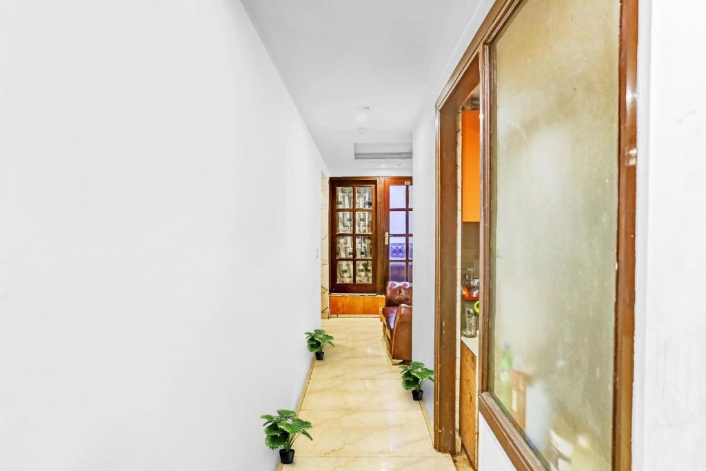 a hallway of a house with a door and plants at Hotel O JANGPURA INN in New Delhi