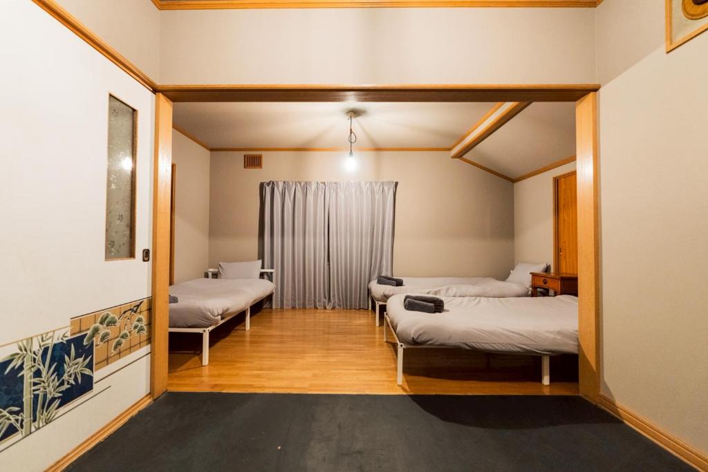 a room with two beds and a window at Cabin Build Take - 竹 in Biei