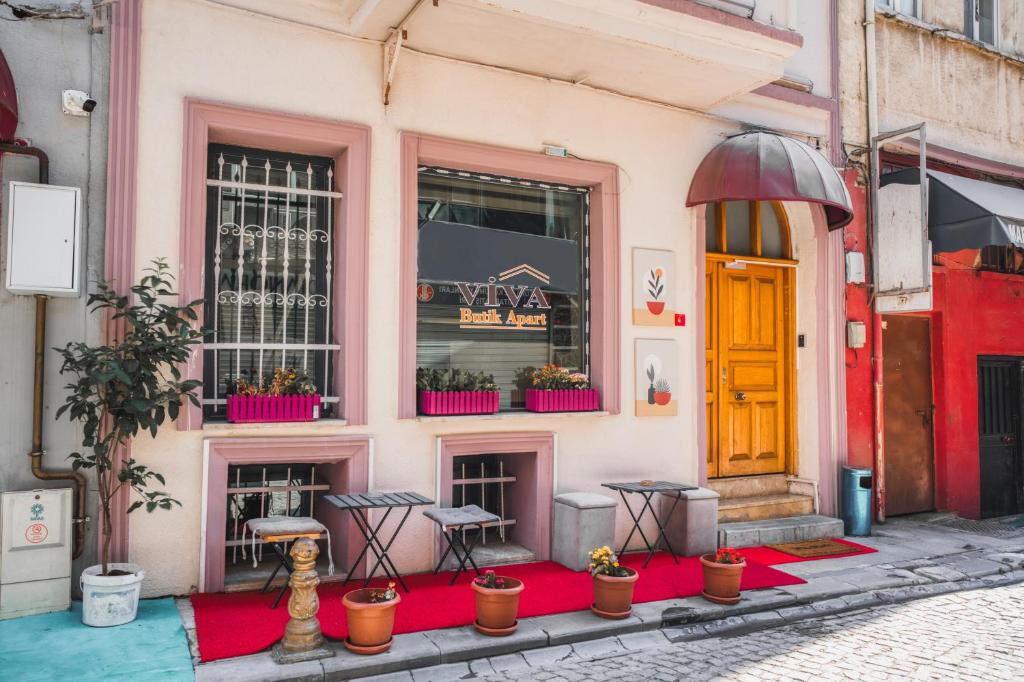 イスタンブールにあるViva Butik Sirkeci Apartのテーブルと鉢植えが置かれたピンク色の建物
