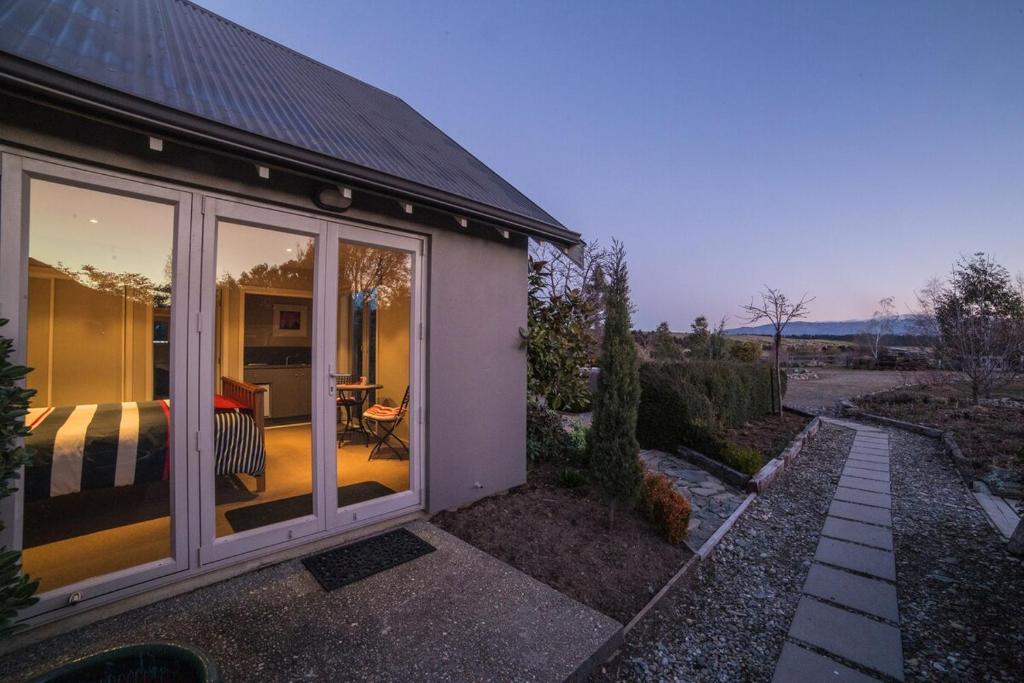 a house with large glass windows and a patio at hawea river retreat in Albert Town