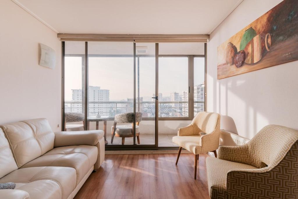 ein Wohnzimmer mit Couch und Stühlen in der Unterkunft Magnificent ocean view from downtown Viña in Viña del Mar