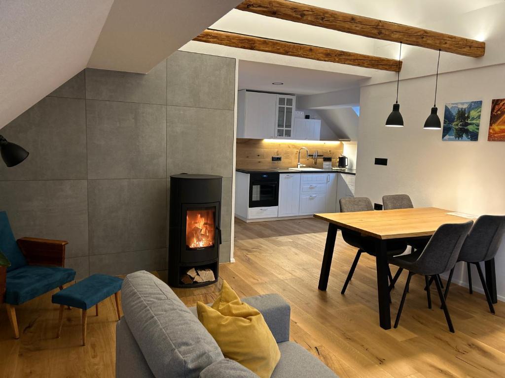 Una sala de estar con una mesa y una chimenea. en Grannys Retreat, en Žiri