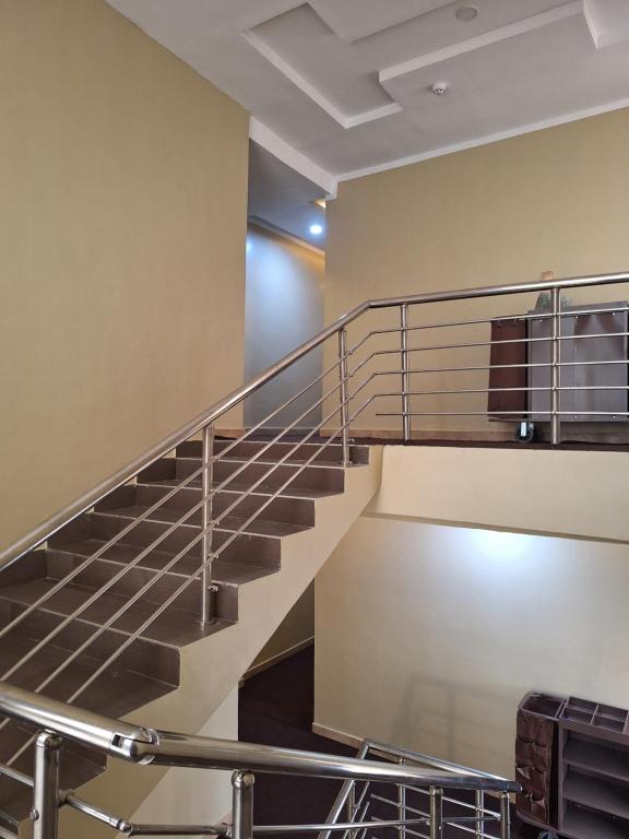 una escalera metálica en un edificio con equipaje en Asato Hotel, en Asaba