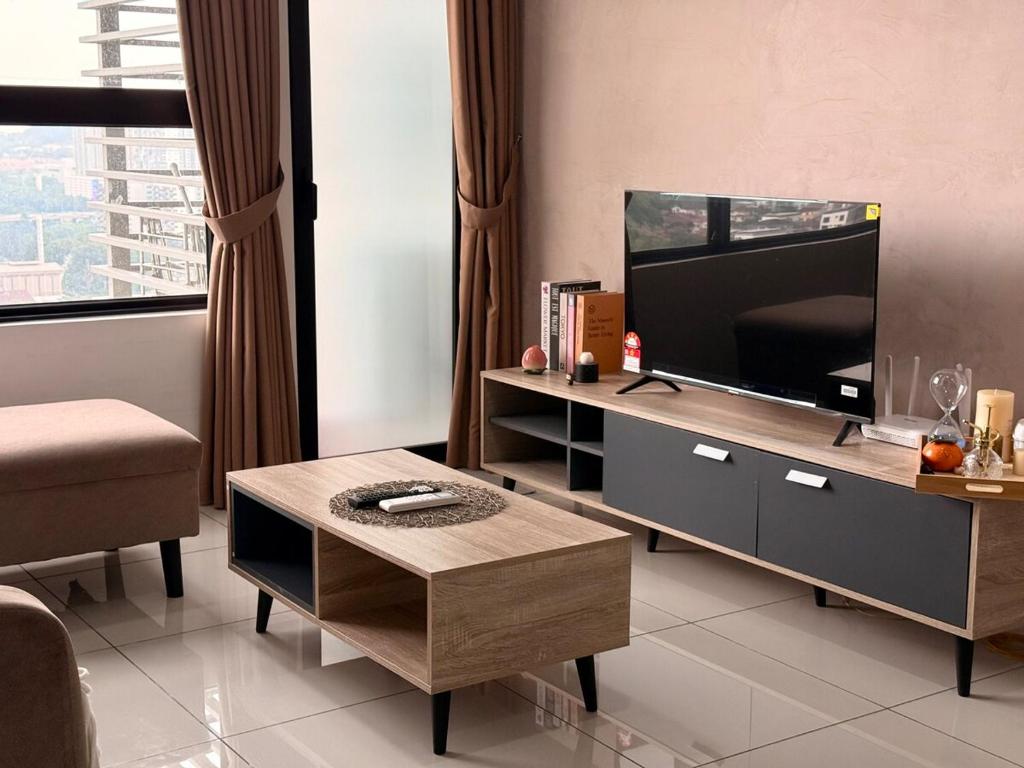een woonkamer met een tv en een salontafel bij Subang Studio 6 Pax Home in Subang Jaya