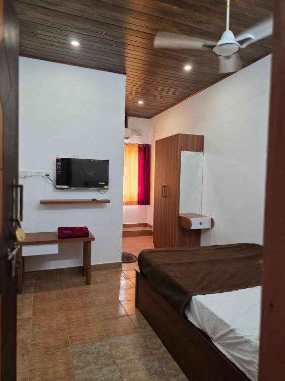 a bedroom with a bed and a tv on a wall at Hotel Prithesh Tourist Home in Bantvāl
