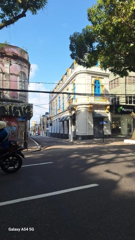 a motorcycle driving down a city street with a building at General Hostel Belém in Belém