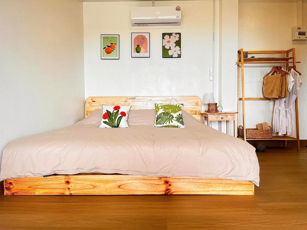 a bedroom with a wooden bed with two pillows at Oxygen-phamee in Ban Pha Mi