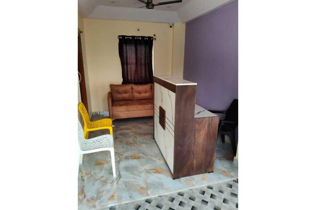 a room with a desk and a chair and a table and a couch at HOTEL O THE HOTEL TRIYA in Warangal