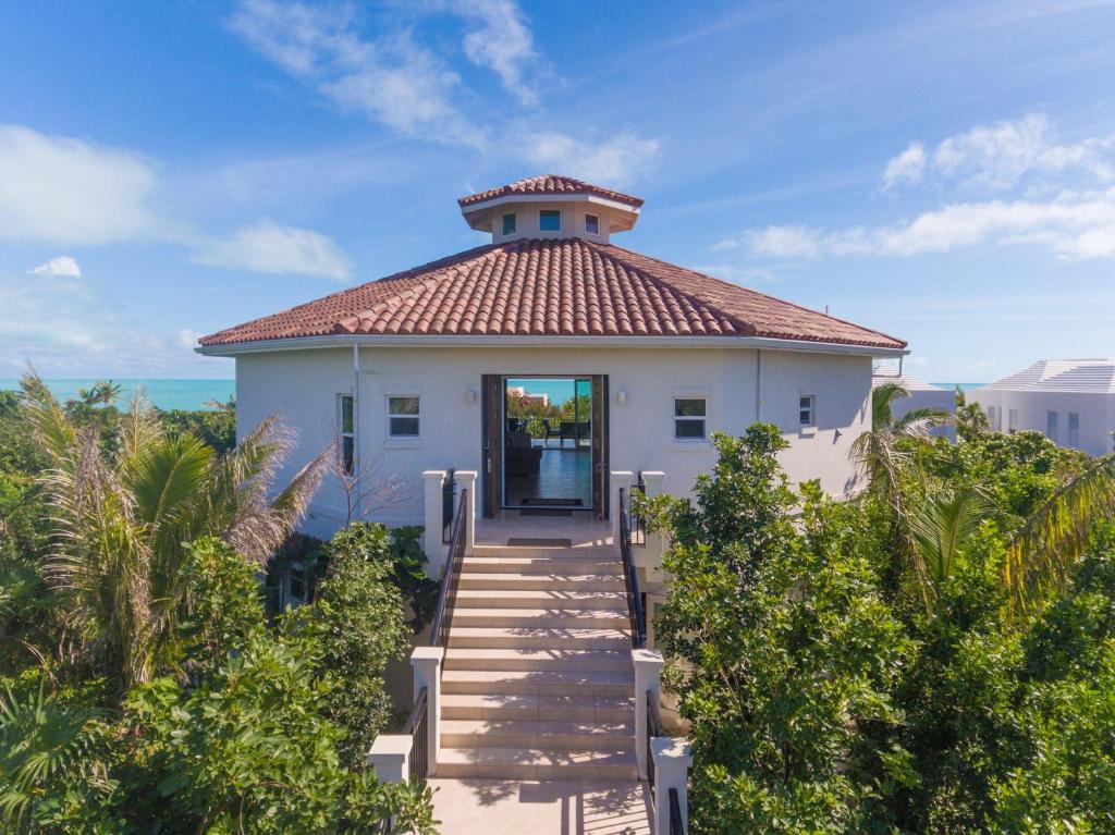 a small white building with a tile roof at Karana 4 Bedroom in Long Bay Hills