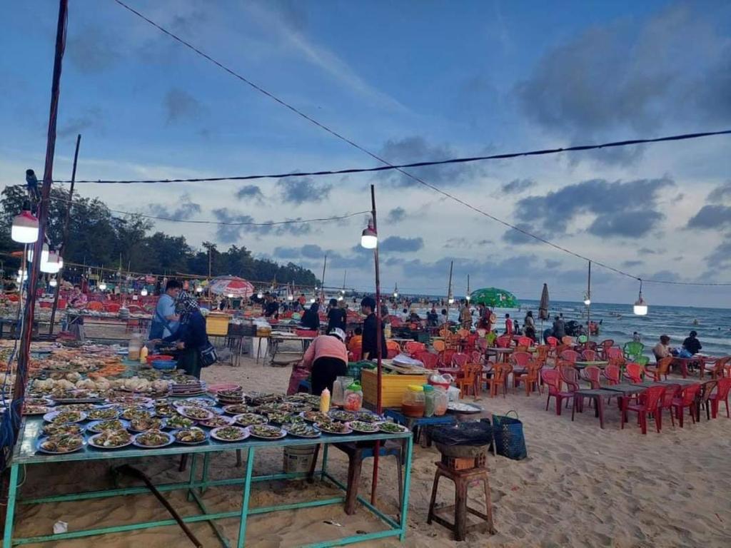 een groep mensen op een strand met tafels en stoelen bij Nhà Nghỉ Việt Thắng Dinh Thầy Thím in La Gi