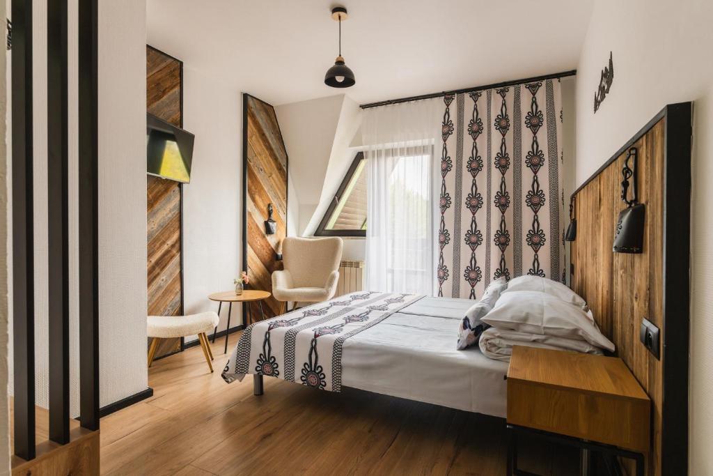 a bedroom with a bed and a desk and a window at Willa Józef in Zakopane