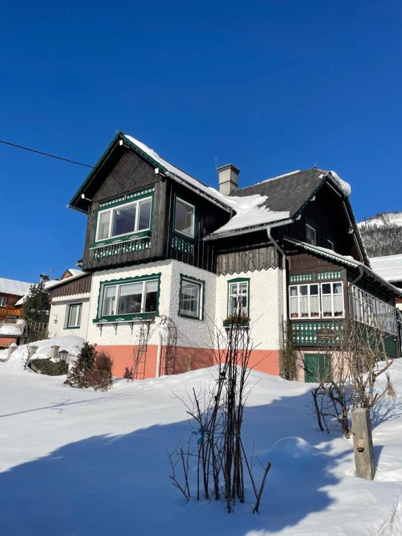 una casa grande con nieve en el suelo en Ferienwohnung Sonnschein, en Bad Mitterndorf