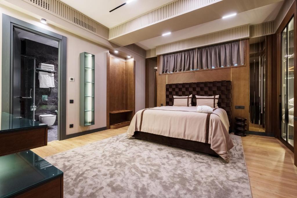 a bedroom with a large bed and a bathroom at Olive Boutique Hotel in Almaty