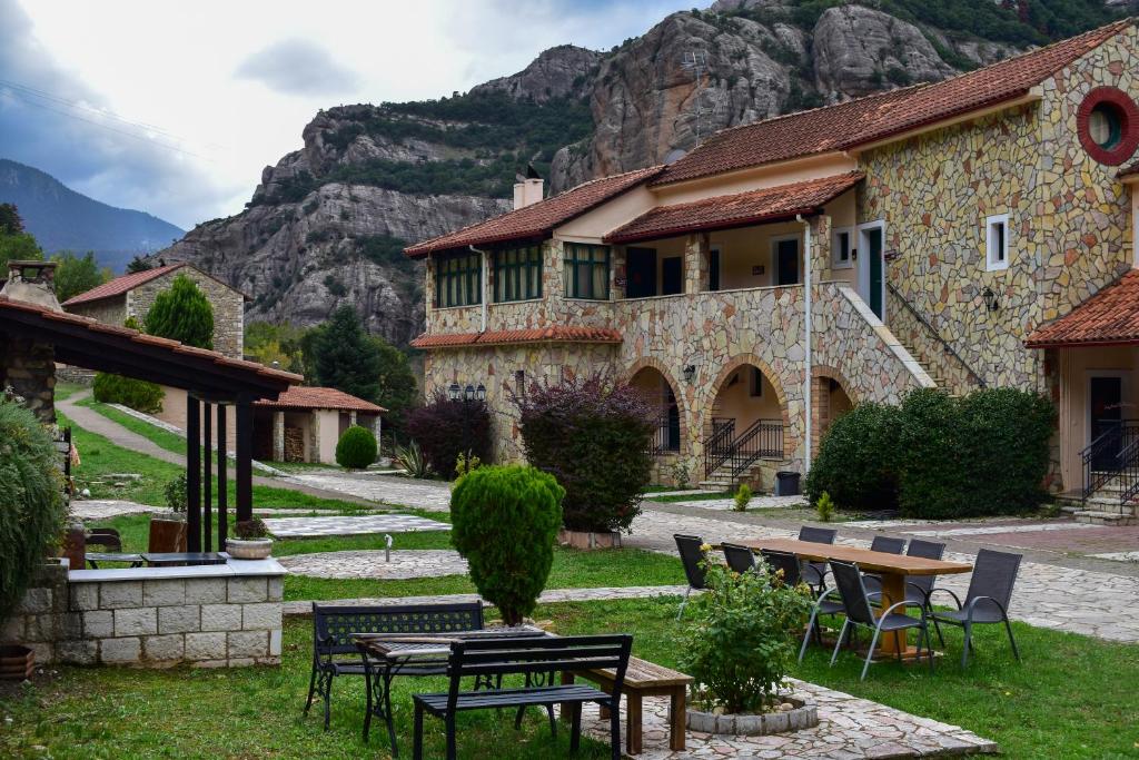 a building with a table and chairs in front of it at Muntenia Inn Apartments and Suites in Kalavrita