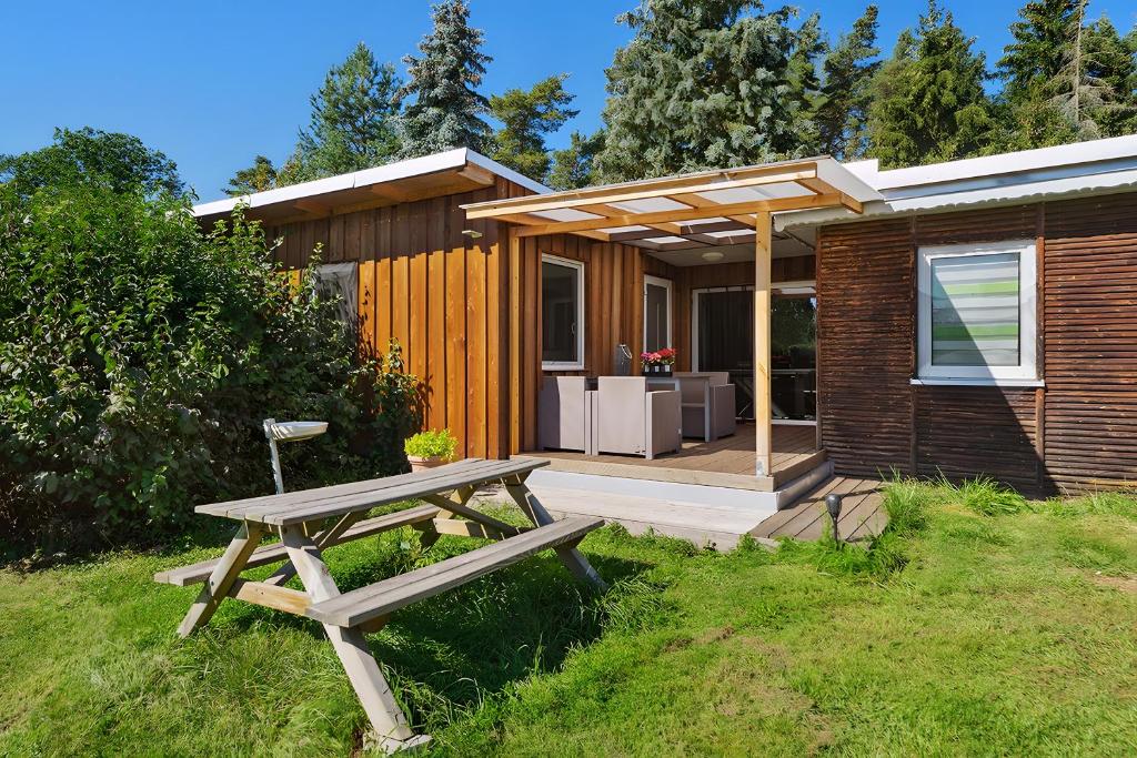 a wooden picnic table in front of a house at Ferienhaus 35 in Stelzendorf
