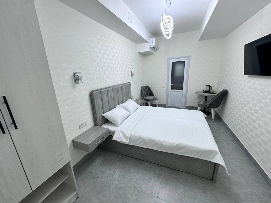 a bedroom with a bed and a tv in it at BEERloga in Samarkand