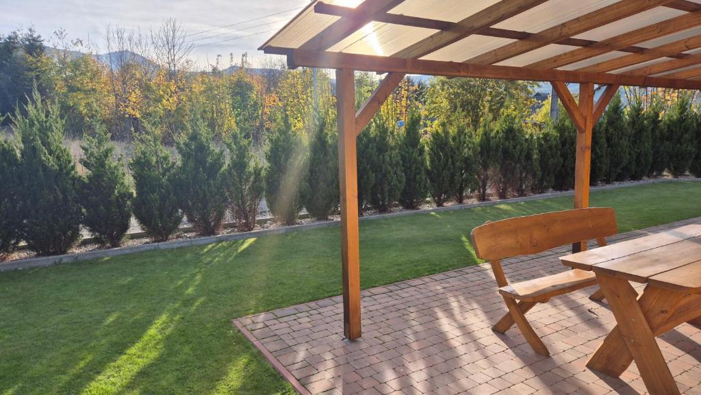 een houten tafel en een houten stoel onder een parasol bij Domek w Karkonoszach 2 in Ściegny