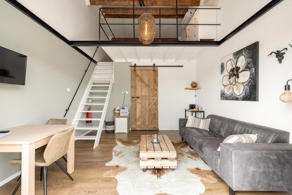 een woonkamer met een bank en een tafel bij BnB Purmerland in Purmerend