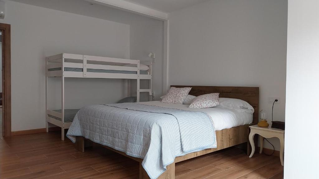 a bedroom with a bed and a bunk bed at La Mar de Nueva AT in Nueva de Llanes