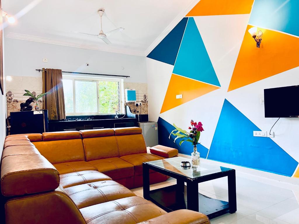 a living room with a couch and a colorful wall at Stunning 4bhk Pool View Apartment 2bhkX2 in Vagator