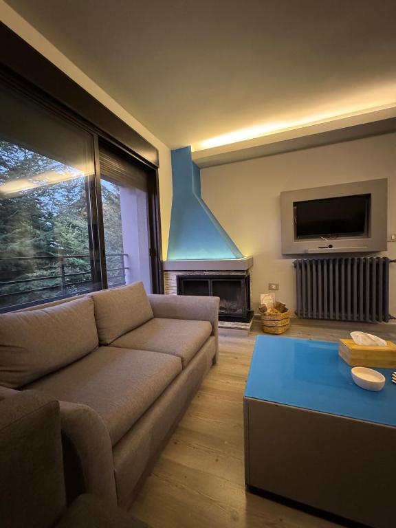 a living room with a couch and a fireplace at The Cozy Inn - Sapphire in Fārayyā