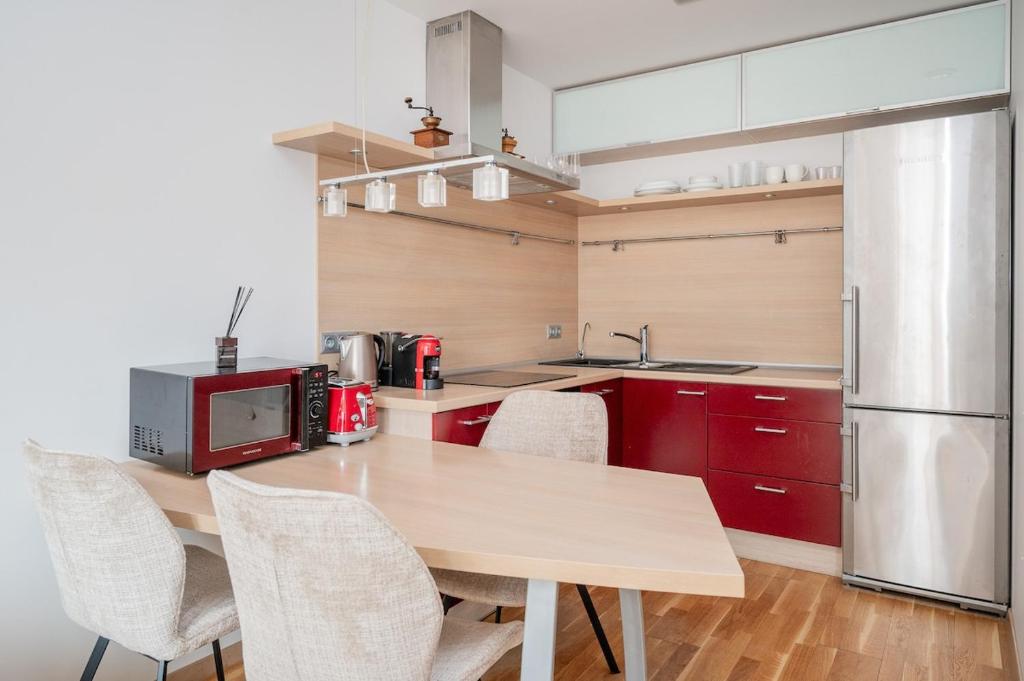 kuchnia z drewnianym stołem i lodówką w obiekcie Studio in central Vilnius w Wilnie