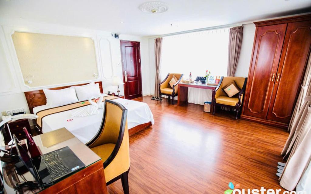 a hotel room with a bed and a desk at ORANGE Hotel & Suites - Danang City CENTER, near Dragon Bridge in Da Nang