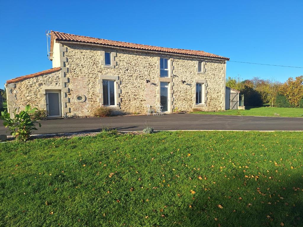 a stone house on the side of a road at Au Cœur Des Champs in La Petite-Boissière