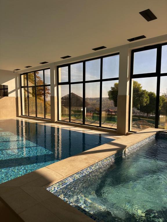 a swimming pool in a building with windows at Vila Aleksandar in Orašac
