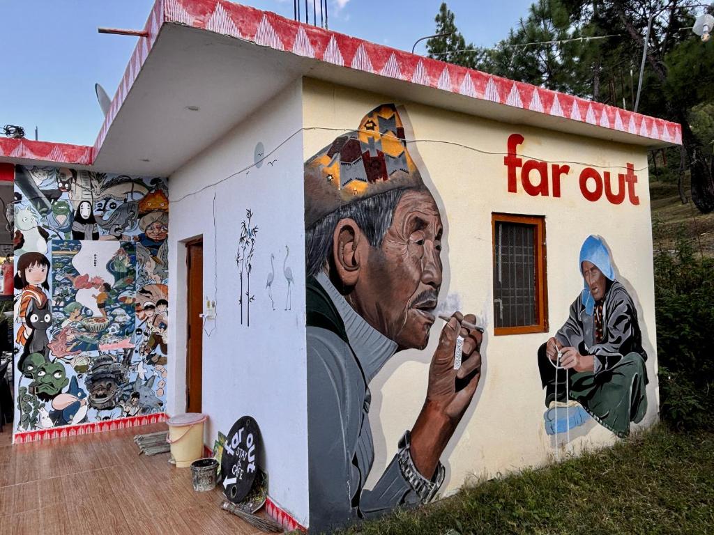 a building with a painting of a man on it at Far out Homestay in Hawālbāgh
